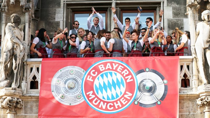 Spielerinnen und Spieler von Bayern München jubeln auf dem Rathaus-Balkon.