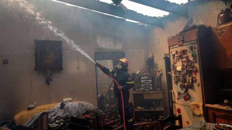 Ein Feuerwehrmann löscht ein Haus im Dorf Hasia in der Nähe von Athen.