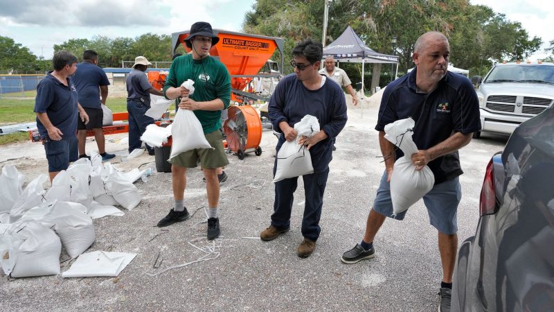 Mitarbeiter der Park- und Freizeitbehörde von Tampa in Florida helfen Anwohnern beim Verladen von Sandsäcken.
