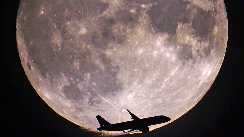 Der Mond wirkt zum Greifen nah: Ein Flugzeug passiert den Vollmond über London.