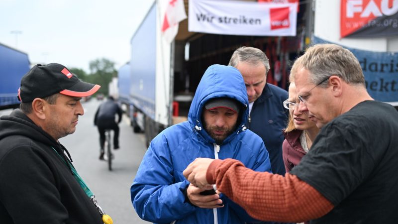 Der niederländische Gewerkschafter Edwin Atema (r) spricht mit den Lkw-Fahrern.