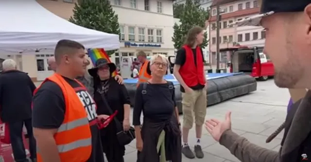 „Warum werde ich ausgegrenzt?“ Weber (r.) erntete für seine Liveberichterstattung auf dem CSD in Weißenfels von einer blonden Dame ein spöttisches „Mimimi&quot;. Foto: Bildschirmfoto/YouTube/Weichreite TV