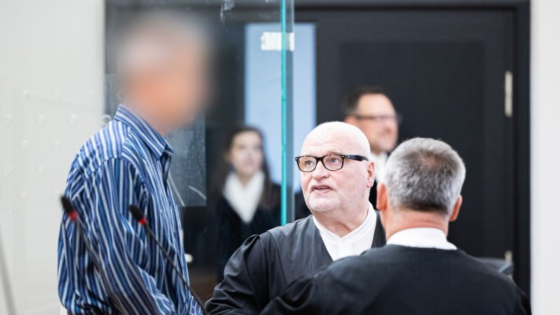 Der Angeklagte (l) vor Beginn des ersten Prozesses in einem Gerichtssaal im Landgericht Hannover. Daneben seine Anwälte Matthias Waldraff (M) und Güney Ralva.