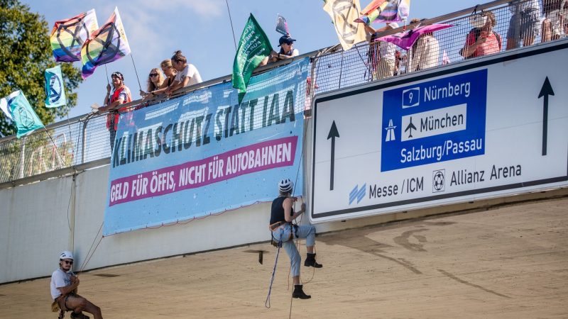 Klimaaktivisten von Extinction Rebellion  seilen sich in München von einer Brücke  ab.