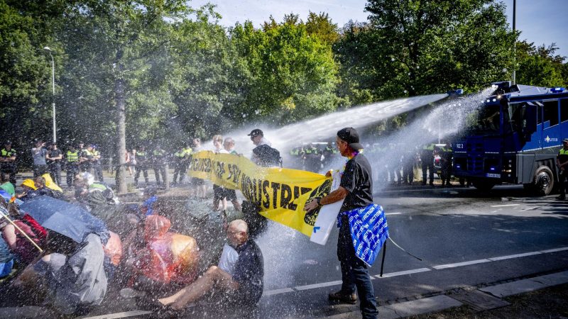 Einsatz von Wasserwerfern gegen Klimaaktivisten, die eine Straße blockieren.