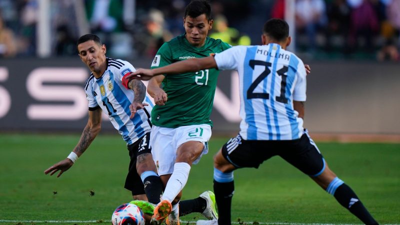 Boliviens Hector Cuellar in Aktion gegen die Argentinier Angel Di Maria (l) und Nahuel Molina (21).