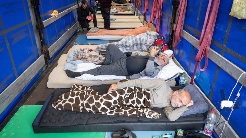 Trucker aus Georgien liegen auf einem Matratzenlager auf der Ladefläche eines Lkw. Sie sind in einen Hungerstreik getreten.