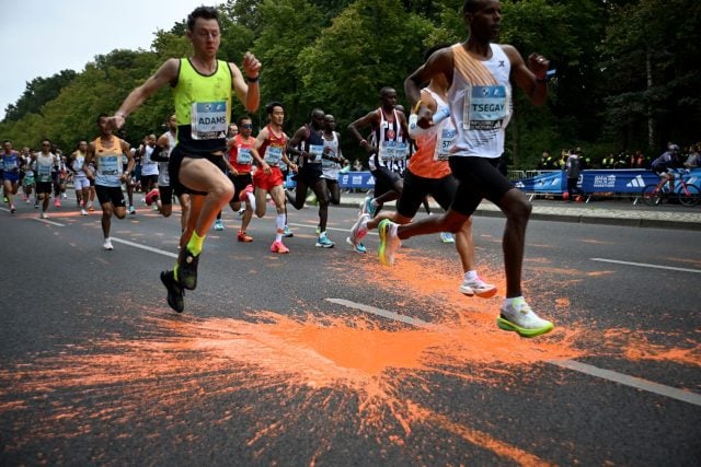 Mit orangener Farbe versuchten Aktivisten der Klimaschutzgruppe Letzte Generation beim Marathon in Berlin auf die Klimakrise aufmerksam zu machen. Ob jetzt auf den Straßen viele orangene Schuhabdrücke zu sehen sind?