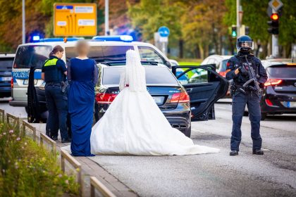 Schwerbewaffnete Polizisten durchsuchen Hochzeitskorso