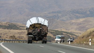 Ein vollbepackter Lastwagen mit Sachen von Flüchtlingen aus Berg-Karabach ist in den Serpentinen des Südkaukasus unterwegs.
