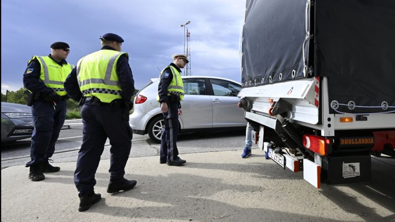 Polizisten kontrollieren einen Lastwagen und Autofahrer am Grenzübergang Berg in Österreich.