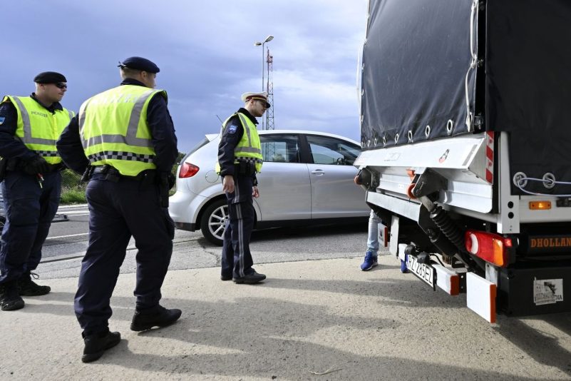 Polizisten kontrollieren einen Lastwagen und Autofahrer am Grenzübergang Berg in Österreich.
