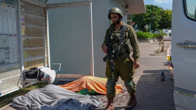 Ein israelischer Soldat steht in Sderot neben den Leichen von Israelis, die von Hamas-Kämpfern getötet wurden.