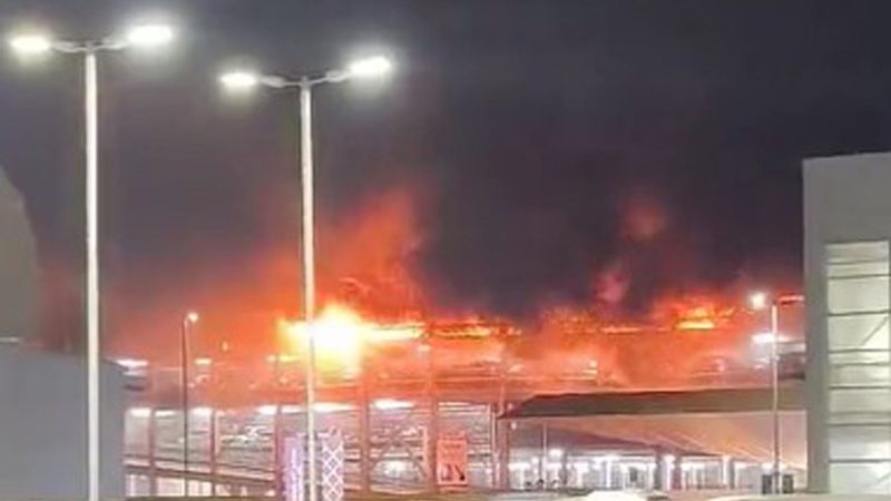 Flammen schlagen aus der obersten Etage eines mit vielen Autos besetzten Parkhauses am Londoner Flughafen Luton (Screenshot aus einem bei X geposteten Video).