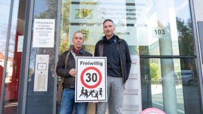 Christian Kronbitter (l) und Erich Maier vor dem Verwaltungsgericht in Freiburg mit einem «Freiwillig 30»-Schild.