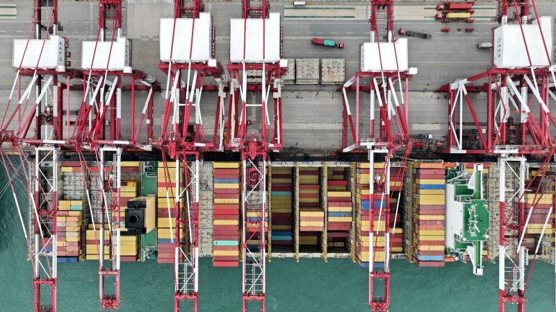 Blick von oben auf ein Containerschiff im Hafen von Qingdao in der ostchinesischen Provinz Shandong.