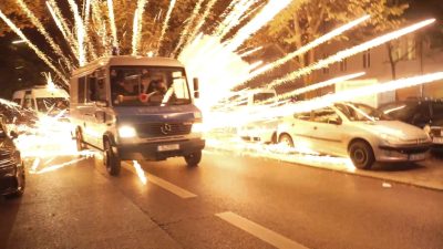 Feuerwerkskörper fliegen hinter einem Polizeiauto bei einer nicht angekündigten pro-palästinensischen Demonstration in Neukölln.