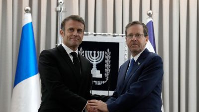 Emmanuel Macron (l), Präsident von Frankreich, schüttelt Izchak Herzog, Präsident von Israel, die Hand. Frankreichs Präsident Macron ist zu einem zweitägigem Besuch in Israel.