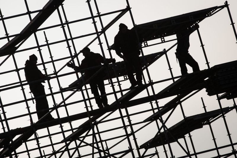 Gerüstbauer errichten ein Gerüst. Die hohe Teuerungsrate und die schwächere Konjunktur dürften die Schwarzarbeit in Deutschland spürbar anheizen. (Symbolbild)