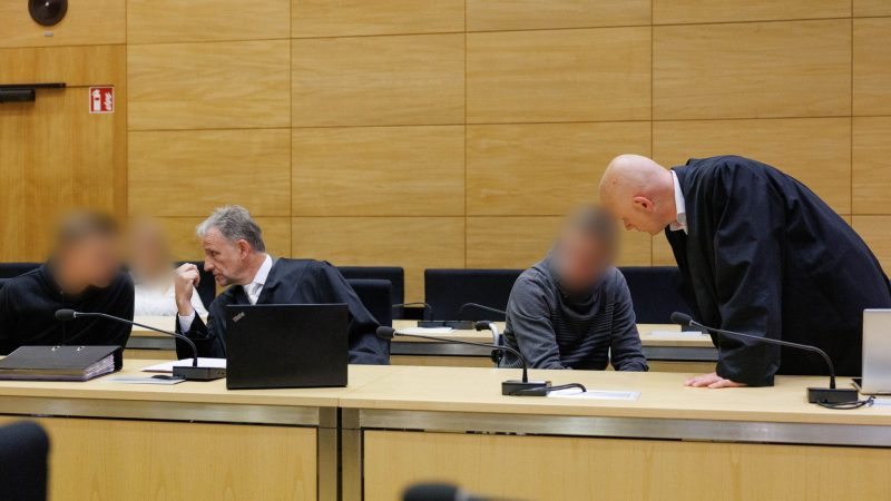 Christian Thüner (2.v.l) und Jerrit Schöll (r), die Verteidiger der Angeklagten, sprechen mit ihren Mandanten in einem Saal des Landgericht Bielefeld zum Auftakt im Prozess um ein illegales Motorradrennen mit Todesfolge.