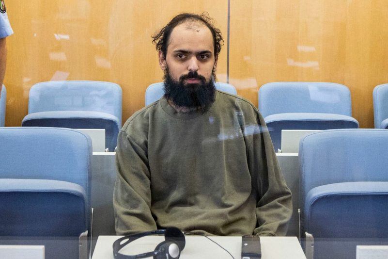 Der Angeklagte sitzt im Oberlandsgericht Düsseldorf auf der Anklagebank hinter einer Glasscheibe.