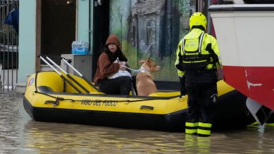 Feuerwehrleute retten eine Anwohnerin und ihren Hund im Ort Campi di Bisenzio.