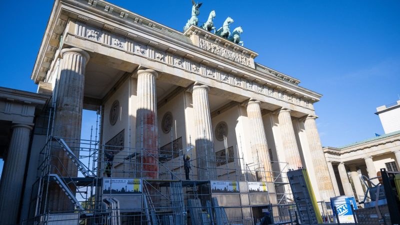 Auf einer Seite des Brandenburger Tors wird ein Baugerüst aufgebaut, um die Folgen der Farbattacke zu beseitigen.