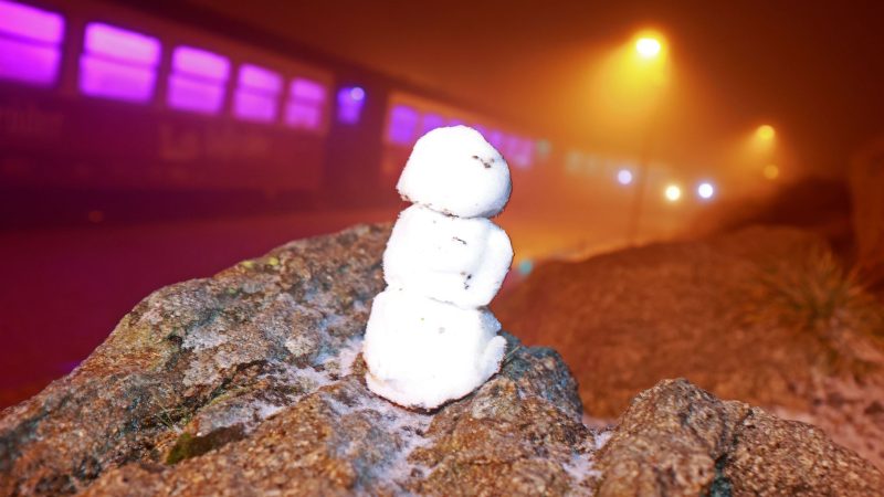 Ein kleiner Schneemann steht auf einem Stein auf dem Brocken.