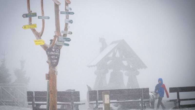 Der mit einer leichten Schneeschicht bedeckte 1215 Meter hohe Fichtelberg liegt im Nebel.