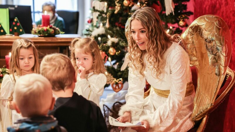 Das Christkind (r) nimmt in der Christkindpostfiliale in Engleskirchen Wunschzettel von Kindern entgegen.