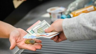 Eine Kassiererin gibt einer Kundin Wechselgeld an der Kasse eines Supermarktes. Die Inflation ist auf dem Rückzug. (Symbolbild)