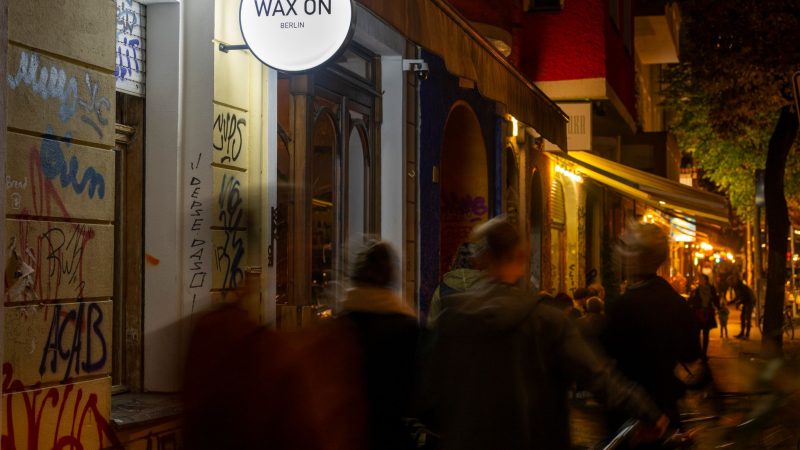 Passanten gehen am Abend vorbei an der Neuköllner Bar «Wax On».