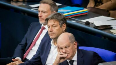 Bundeskanzler Olaf Scholz (SPD, r-l), Wirtschaftsminister Robert Habeck (Bündnis 90/Die Grünen) und Finanzminister Christian Lindner (FDP) verfolgen im Plenum des Deutschen Bundestages die Debatte.