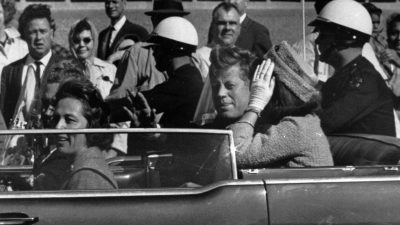 Kurz vor seiner Ermordung sitzt der damalige US-Präsident John F. Kennedy am 22.11.1963 in Dallas zusammen mit seiner Frau Jacqueline Kennedy (r) sowie dem dem Gouverneur von Texas, John Connally, und desen Frau Nellie Connally in einer offenen Limousine.