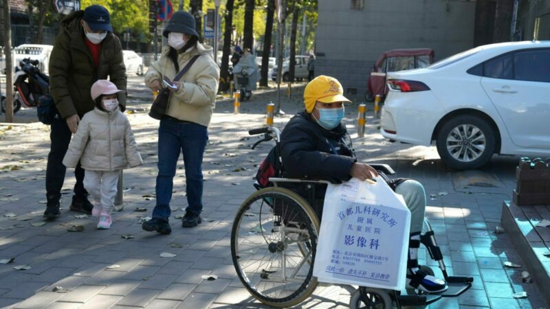 Ein Junge in einem Rollstuhl hält in Peking eine Tasche aus der radiologischen Abteilung eines Kinderkrankenhauses. In den vergangenen Tagen hatten Berichte über die starke Häufung von Atemwegserkrankungen bei Kindern Sorgen aufkommen lassen.