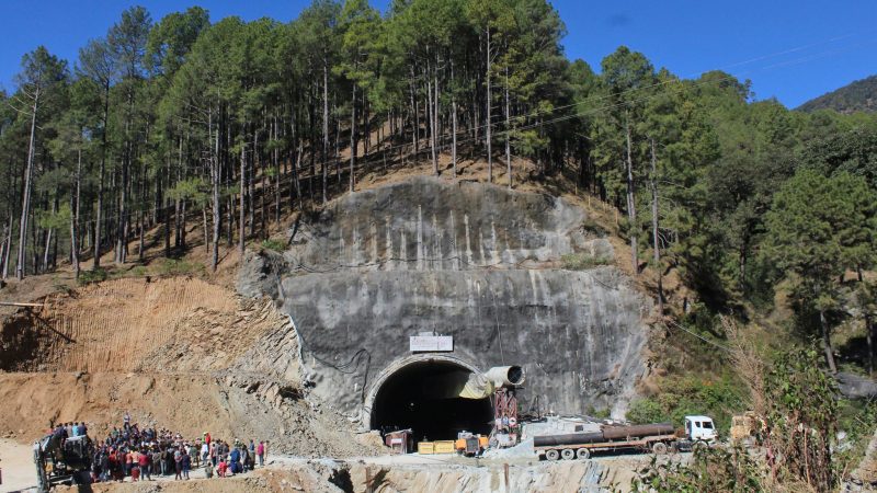 Menschen beobachten Rettungs- und Hilfsmaßnahmen an der Stelle eines im Bau befindlichen Straßentunnels, der im indischen Bundesstaat Uttarakhand eingestürzt ist.