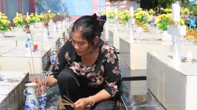 Nguyen Thi Nhiem zündet Räucherstäbchen auf einem Friedhof an und betet für die Seelen der ungeborenen Kinder.