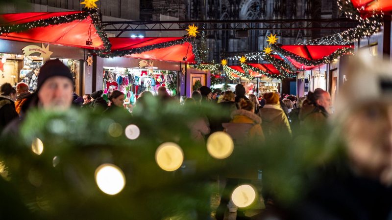 Der Weihnachtsmarkt am Kölner Dom ist am Abend gut besucht.
