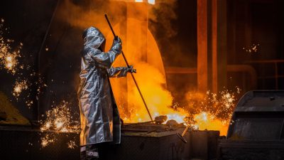 Ein Stahlarbeiter von Thyssenkrupp prüft den Roheisen am Hochofen.