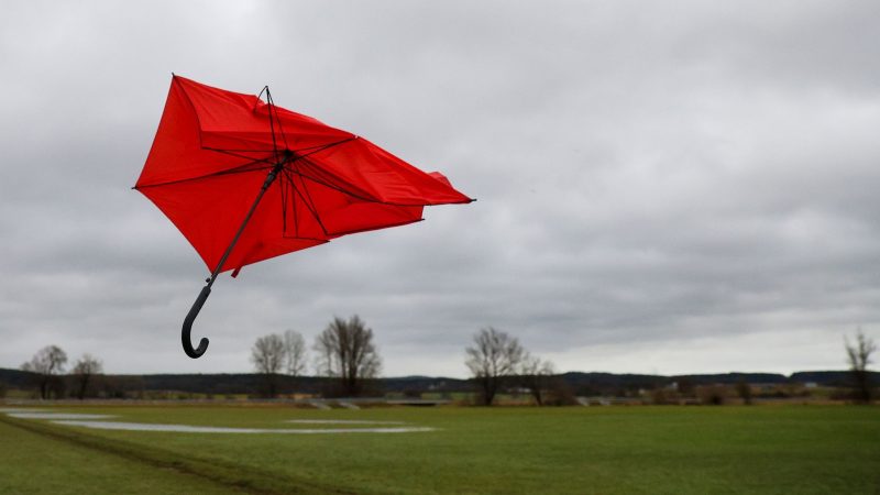 Ein kaputter Regenschirm fliegt im Wind.