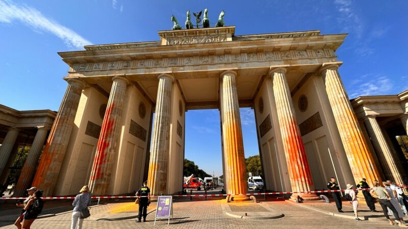 Mitglieder der Klimaschutzgruppe Letzte Generation sprühen im September das Brandenburger Tor mit oranger Farbe an.