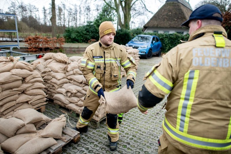 Einsatzkräfte der Feuerwehr geben auf einem Parkplatz in Oldenburg zahlreiche Sandsäcke an die Anwohner im Bereich der Hunte am Achterdiek aus. Die Hochwasserlage bleibt in vielen Regionen Niedersachsens angespannt.