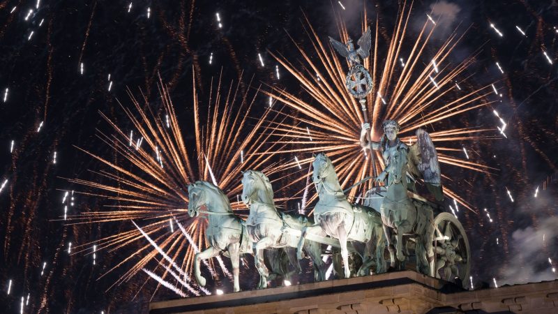 Das Feuerwerk zum Jahreswechsel steigt hinter dem Brandenburger Tor auf.