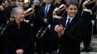 Elisabeth Borne, scheidende Premierministerin von Frankreich, lächelt dem neu ernannten Premierminister Gabriel Attal nach der Übergabezeremonie in Paris zu.