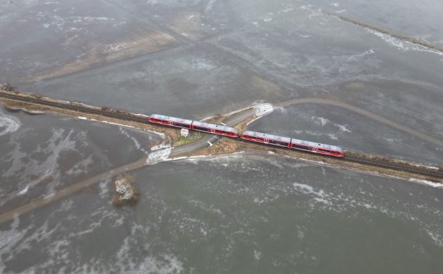 Aus der Eisfläche ragt eine Bahnstrecke. Durch die frostigen Nächte ist das Hochwasser der Nidder im Süden Hessens gefroren.