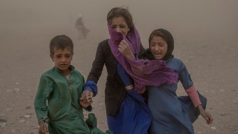 Afghanische Kinder versuchen während eines Sandsturms gespendete Hilfsgüter zu ihren Zelten zu tragen. Inzwischen liegt das verheerende Erdbeben in Afghanistan mehr als drei Monate zurück.