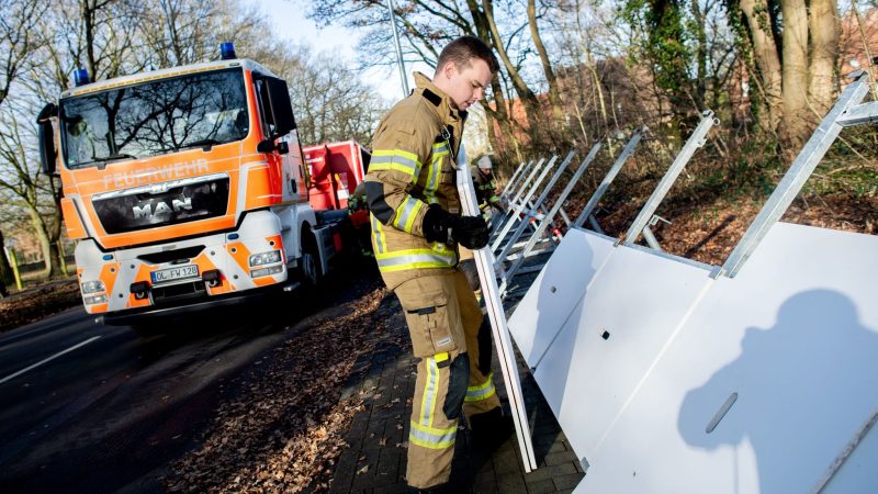 Einsatzkräfte der Feuerwehr bauen ein mobiles Deichsystem ab.