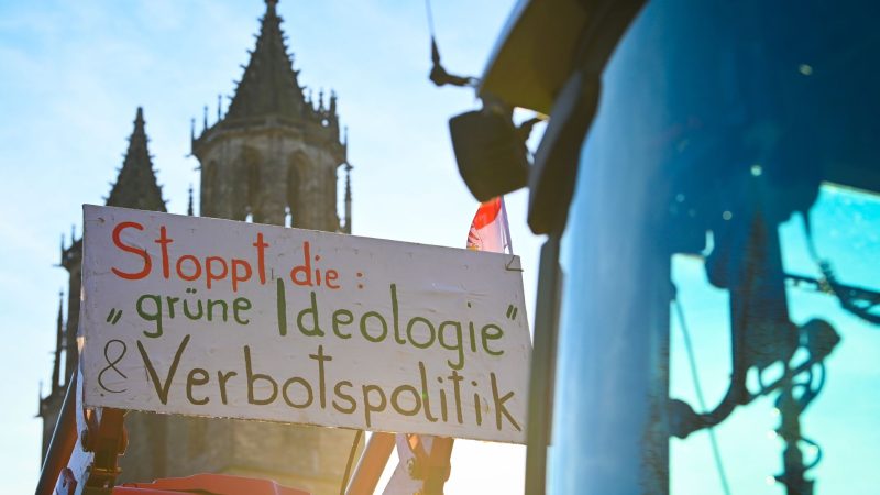 Das Motto lautet «Zu viel ist zu viel»: Ein Protestplakat mit der Aufschrift «Stoppt die grüne Ideologie und Verbotspolitik» ist an einem Traktor vor dem Dom in Magdeburg befestigt.