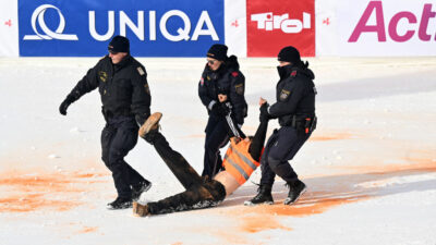 Policeman remove a climate activist of the Last Generation movement from the finish area of the men's Alpine World Cup slalom race in Hochgurgl, Austria on November 18, 2023. (Photo by KERSTIN JOENSSON / AFP) (Photo by KERSTIN JOENSSON/AFP via Getty Images)