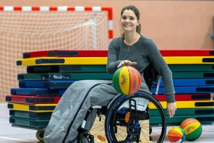 Lehrerin im Rollstuhl unterrichtet Grundschüler im Sport